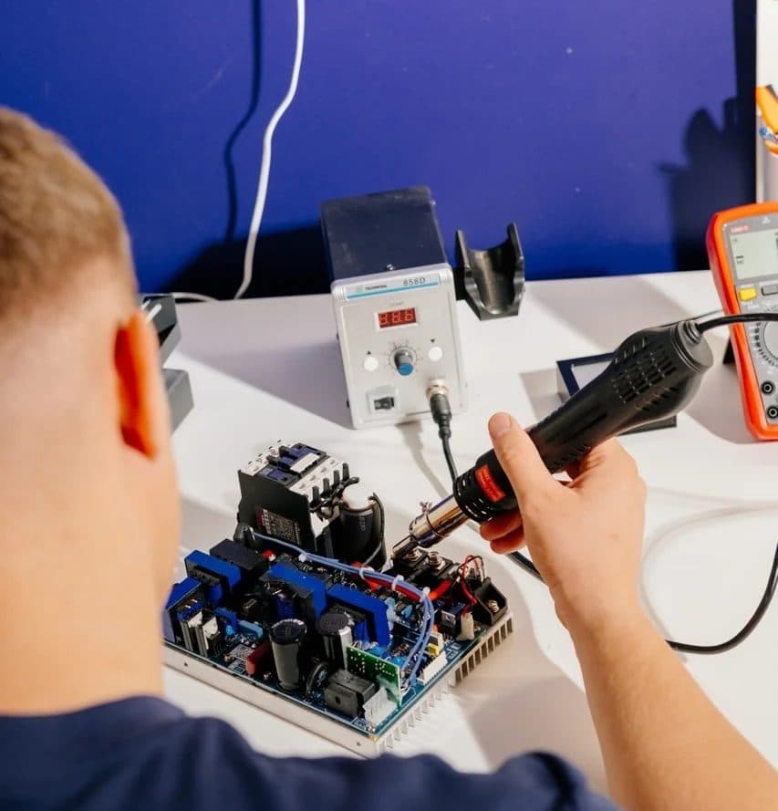 Technik serwisujący płytę lasera w pracowni Modestic, 2023